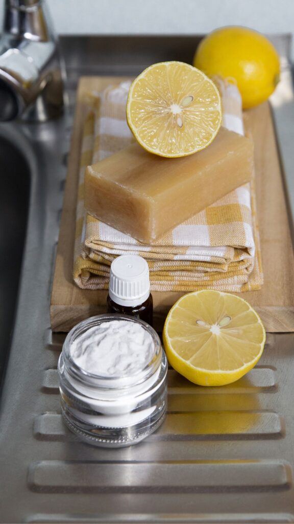 a towel, soap, essential oil and lemon, ingredients to make a non-toxic cleaning spray on a wood cutting board