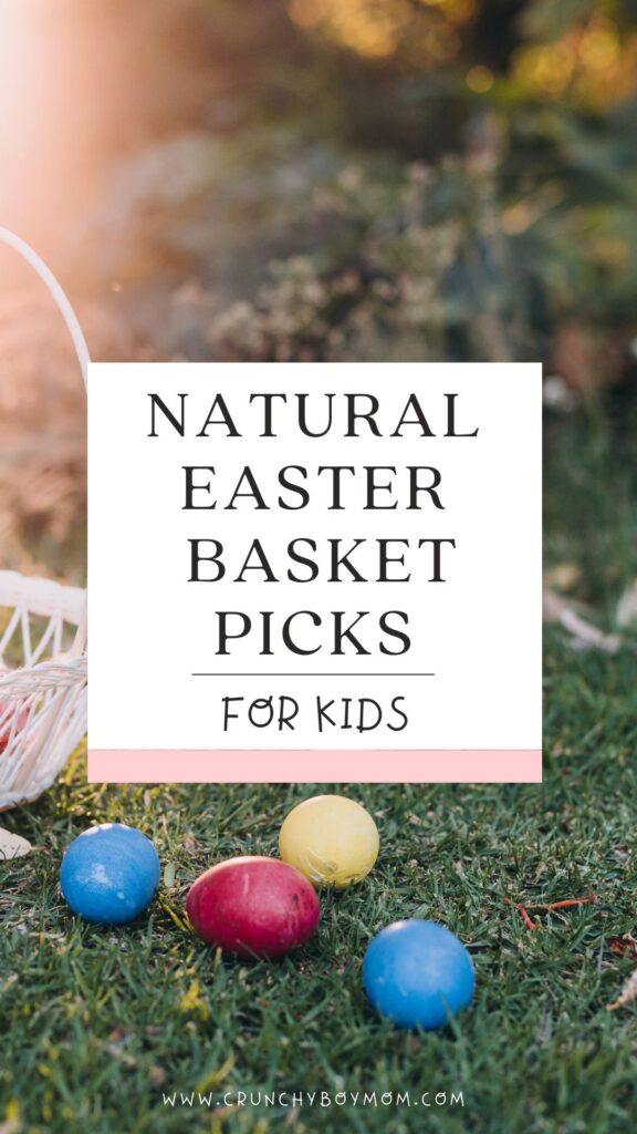 a white Easter Basket sitting on green grass with 4 colored Easter eggs laying on the ground in front of it, 2 blue, one yellow and one red.